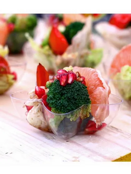 A vibrant and healthy appetizer cup with broccoli, grapefruit, and pomegranate seeds, showcasing our focus on fresh, high-quality ingredients.