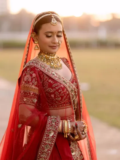 A moment of quiet reflection before the ceremony. Her makeup features soft, defined eyes and a flawless base, creating a look of serene beauty.