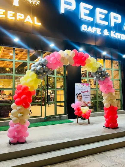 A welcoming balloon arch at the entrance of a cafe for a birthday party. The colorful arch invites guests into the celebration.