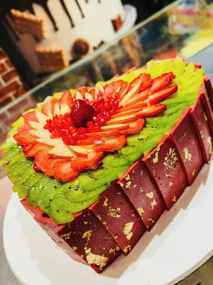 Another angle of the stunning fresh fruit heart cake, showing the geometric chocolate collar.