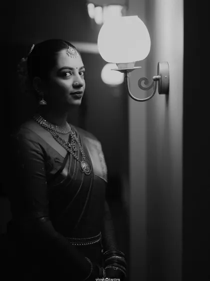 A dramatic black and white portrait of a South Indian bride. This artistic shot highlights the timeless elegance of her look, from the makeup to the traditional attire.