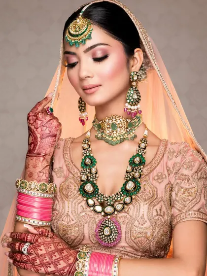 A soft and romantic bridal close-up, focusing on the delicate henna, the pastel lehenga, and the stunning polki jewelry.