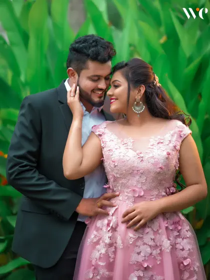 An intimate portrait from a garden pre-wedding shoot. The lush green background makes the couple's connection the central focus of the image.
