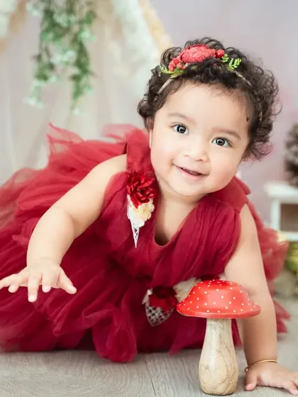 A whimsical woodland theme with a red tutu and mushroom prop. This setup is perfect for a fairytale-inspired photoshoot.