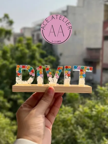 A personalized monogram stand for Divit. The resin letters are filled with colorful flowers and set on a wooden base, making it a perfect decoration for a desk or shelf.