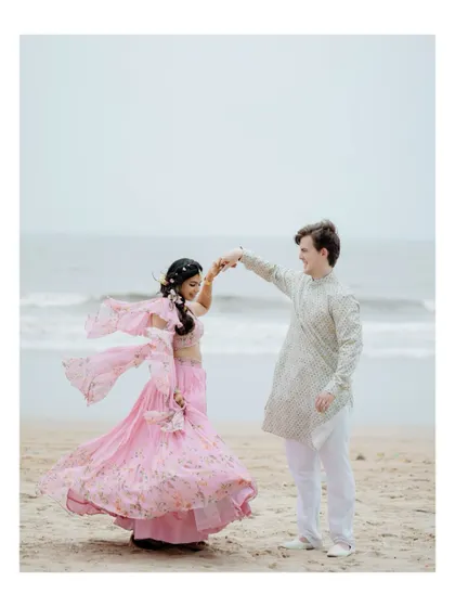 A beautiful shot of the groom twirling his bride on the beach. Her flowing lehenga and the ocean backdrop make this a dreamy, cinematic portrait.