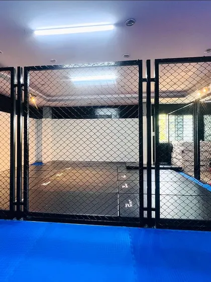 Different views of our MMA cage and the surrounding dojo. We've invested in top-tier infrastructure to give our fighters a competitive edge.