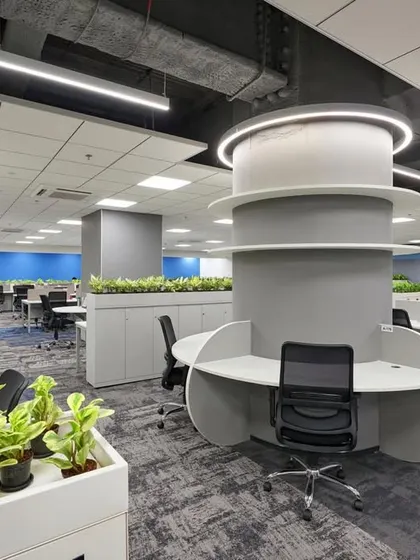 This workspace is organized around a central column that has been transformed into a circular, multi-user workstation. Planters are integrated throughout the space to improve air quality and aesthetics.