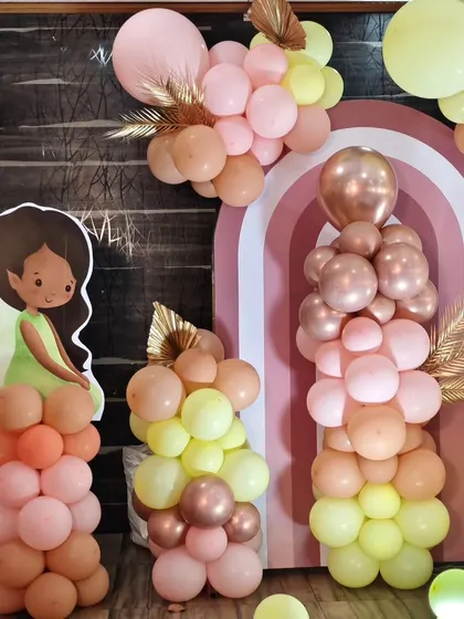A beautiful shot of the balloon pillars and fairy cutout at Nithiksha's party, showcasing the soft, earthy color palette.