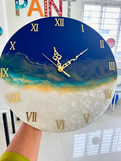 A beautiful resin clock with a golden-hour beach theme, blending warm yellow tones with white foamy waves.