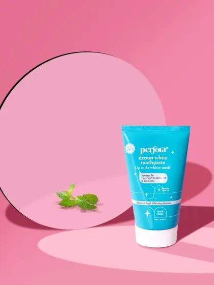 A minimalist and modern shot for Perfora toothpaste. The use of a circular mirror and a single sprig of mint against a color-blocked background creates a clean, artistic, and memorable image.