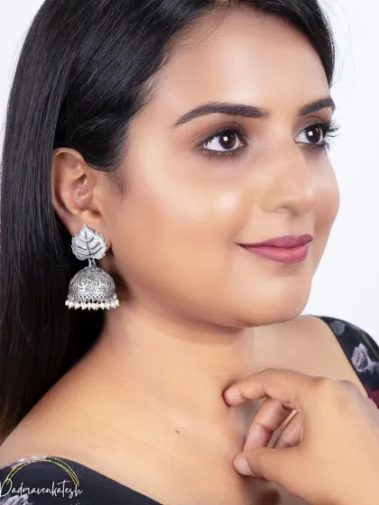 A clean, fresh look for an e-commerce shoot. The goal is to make the model look polished while keeping the focus entirely on the leaf-design silver jhumka. It's all about creating the perfect canvas.
