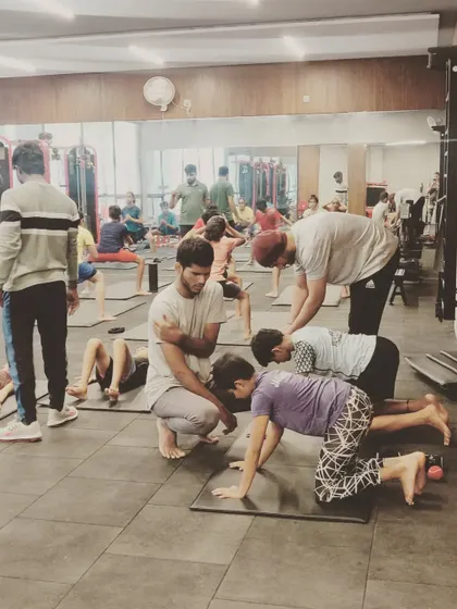 Our trainers providing hands-on guidance during a yoga and flexibility session for young athletes to improve their range of motion.
