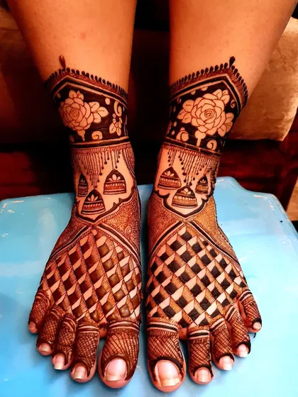 A classic bridal foot design featuring bold geometric patterns and delicate floral details around the ankles. The dark stain shows the quality of my natural henna.