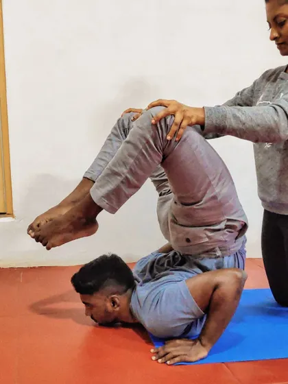 A different angle of the assisted scorpion pose. The support at the hips and legs allows the spine to open up more freely.