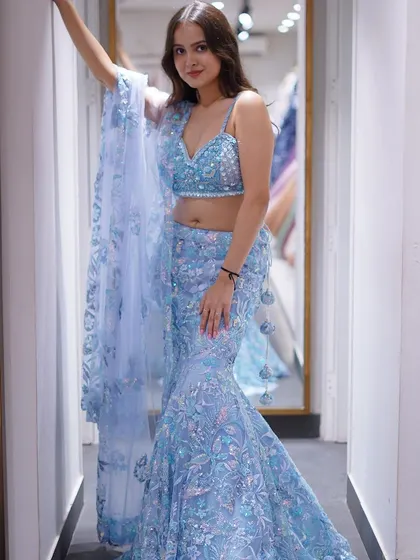 Dive into the magic of this celestial blue fish-tail lehenga. The all-over sequin and floral embroidery shimmers like the night sky, making it an ethereal choice for an evening event.