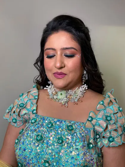 A creative carnival look with a light green and blue lehenga, featuring small gems near the eyes for a touch of sparkle.