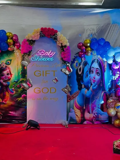 A focused shot of the baby shower stage, highlighting the neon sign, butterfly details, and the colorful character backdrops.