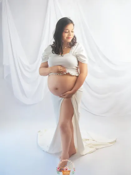 In this pose, the mom-to-be gently cradles her bump, creating a feeling of peace and connection. The all-white theme emphasizes the purity and beauty of this special time.