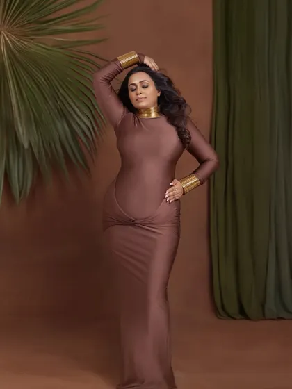 A powerful and statuesque pose in a form-fitting brown gown, accented with gold jewelry for an Egyptian goddess feel.