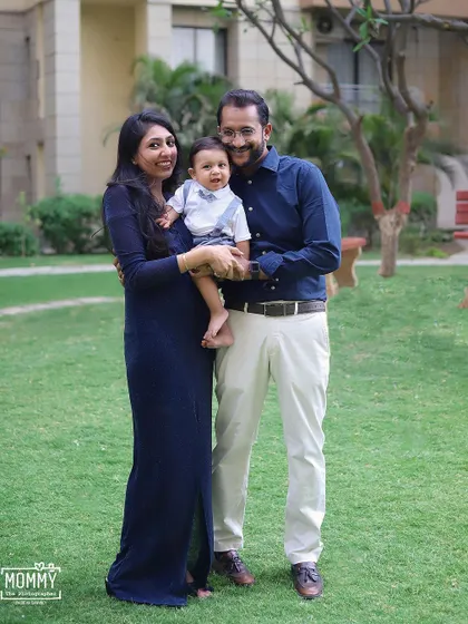 A happy family enjoying a beautiful day outside. Outdoor family photoshoots are perfect for capturing natural smiles and relaxed poses in a lovely green setting.
