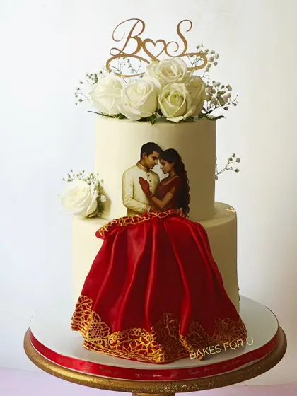 I designed this unique two-tier wedding cake to capture the couple's portrait in an artistic way. The bride's flowing red lehenga is crafted from edible lace, creating a stunning 3D effect that makes the cake truly one-of-a-kind. It’s a beautiful blend of personal art and delicious flavor for your engagement or wedding.
