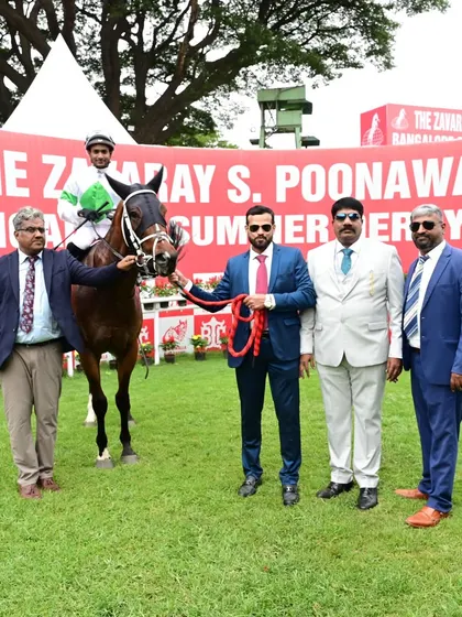 Money Bags, with jockey Akshya Kumar, stands with the winning owners after a successful race.
