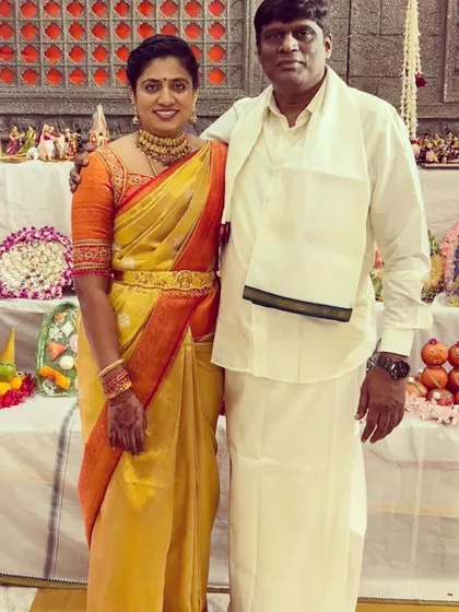 A lovely couple. I designed the wife's orange blouse with traditional embroidery to perfectly complement her yellow and orange silk saree.