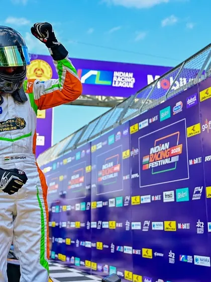 A driver celebrates a victory at the Indian Racing Festival. We create the perfect backdrop for these triumphant moments with extensive branding and a professional podium setup.