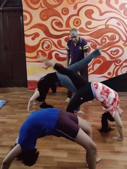 In our studio, we provide personal attention to help you safely progress in your practice. Here, I am guiding students through various backbends like Chakrasana (Wheel Pose), ensuring correct alignment and support for everyone.