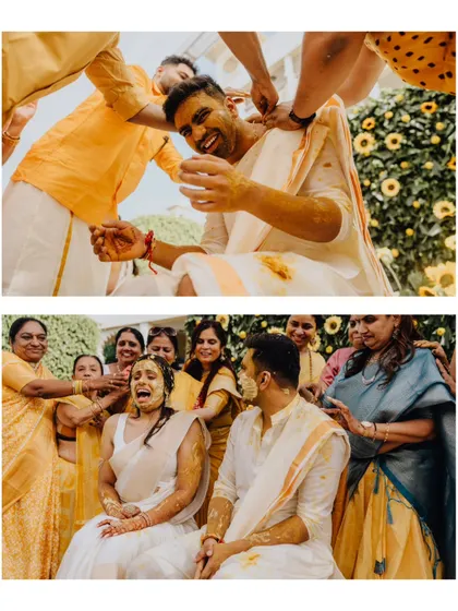 The bride and groom getting playfully doused in turmeric by their loved ones. The expressions of joy and surprise are priceless.