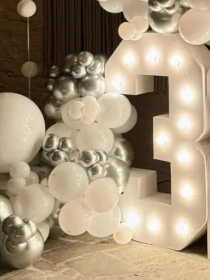 A close-up on the detail. The combination of large and small balloons in white and chrome silver creates a dynamic and visually interesting organic garland.