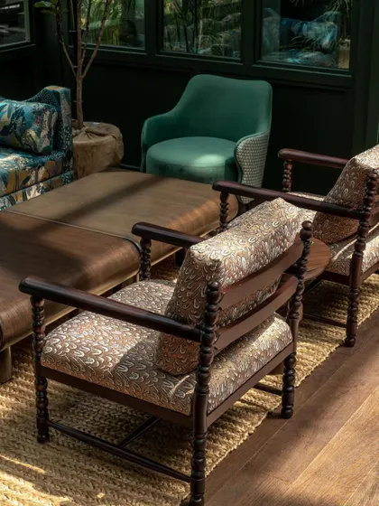 A seating arrangement at the Lord Elgin Glasshouse, showcasing the use of traditional furniture forms with rich, patterned upholstery. The design creates a comfortable yet elevated lounge area, perfect for enjoying the garden views.
