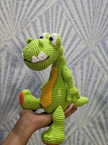 A side view of the handmade dinosaur, showing his long tail.