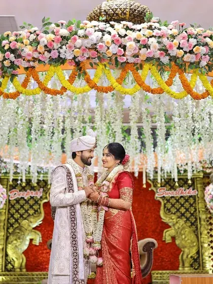 A grand portrait of the couple under a magnificent floral mandap. We ensure we capture both the intimate emotions and the grand scale of your wedding decor and setup.
