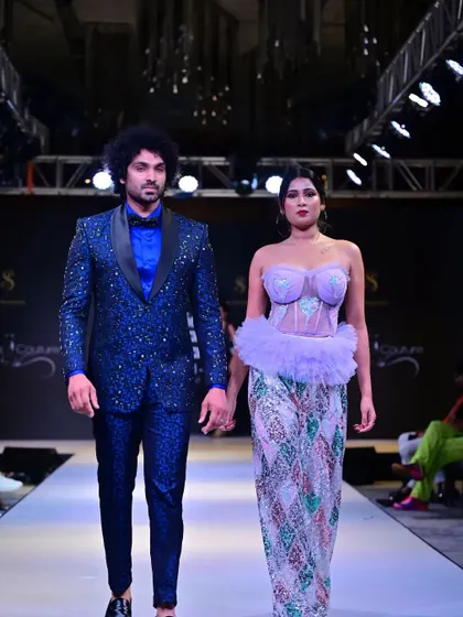 A different angle of the coordinated couple's walk, emphasizing the intricate patterns and textures of the outfits.