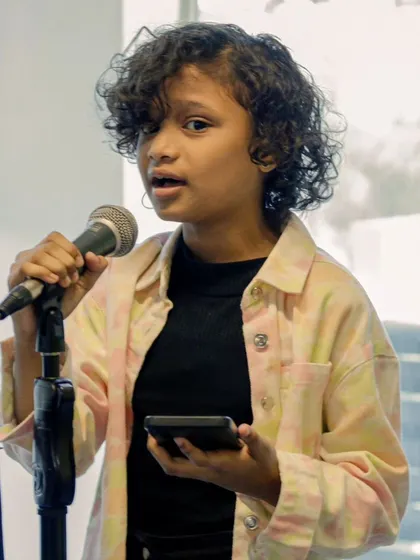 A young vocalist confidently performing at a student recital. We aim to build this level of stage presence from an early age.