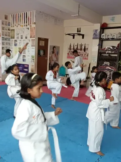 I guide a class of young students as they practice their front kicks.