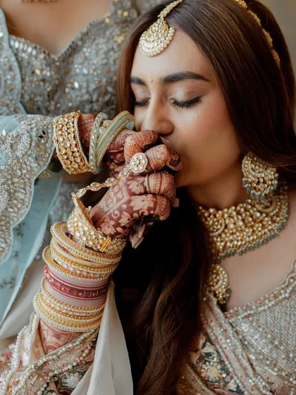 An intimate and emotional moment between sisters. One sister kisses the other's hand, a gesture full of love and blessings for the bride on her big day.
