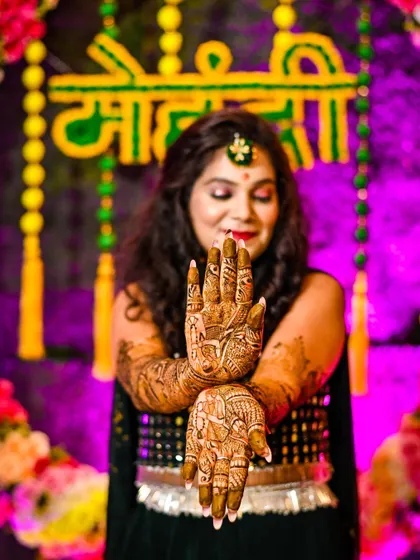 A close-up of the bride's hands, showcasing the detailed and beautiful patterns of her wedding mehndi. We pay close attention to these important details.