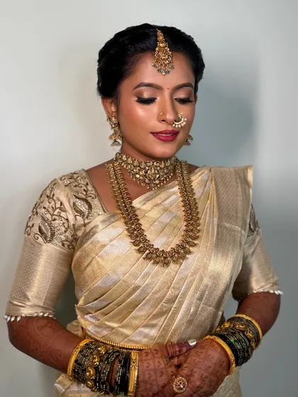 A close-up of Archana's makeup. The soft eye makeup and the perfectly chosen lip color complement her golden saree and her natural beauty.