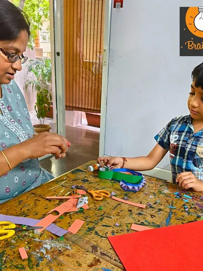 One-on-one guidance is key to our teaching philosophy. Here, I'm helping a student with a tricky part of his paper craft, ensuring he can complete his project with confidence.