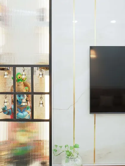 A close-up of a custom pooja unit integrated into the living room furniture. The fluted glass door with traditional bells offers a glimpse of the serene space within, blending devotion with modern design.