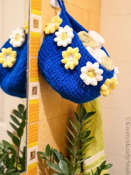 Add a touch of handmade charm to your powder room. This blue hanging basket with crochet daisies is perfect for storing towels or toiletries in style.