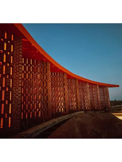 The perforated brick facade glows from within at dusk. This technique of creating a "breathing" wall is central to my passive cooling strategy and creates a beautiful visual effect.