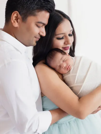 A close-up of new parents adoring their sleeping newborn. This intimate shot captures the overwhelming love and tenderness of the first few days of parenthood.
