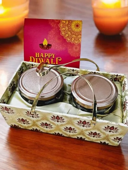 A simple yet elegant Diwali gift, this brocade basket holds two glass jars perfect for dry fruits or sweets. It's a great budget-friendly option for bulk orders.