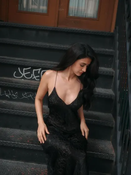 An edgy, urban shot of Disha Patani on the steps in NYC. The glamorous hair and makeup provide a beautiful contrast to the gritty city background.