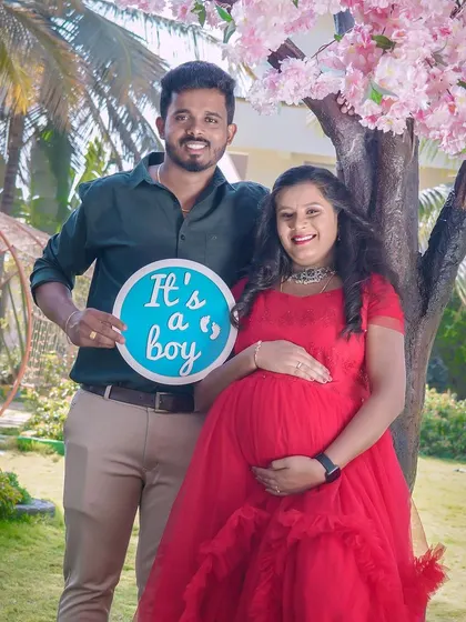 A joyful gender reveal for a baby boy. This couple is celebrating under a beautiful cherry blossom tree setup outdoors.