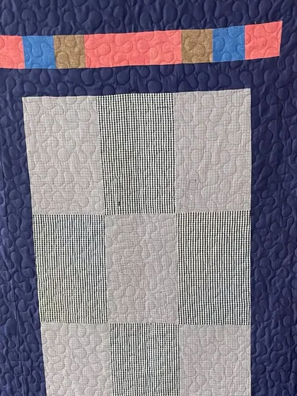 The back of a memory quilt made from shirts, featuring a simple, elegant design.
